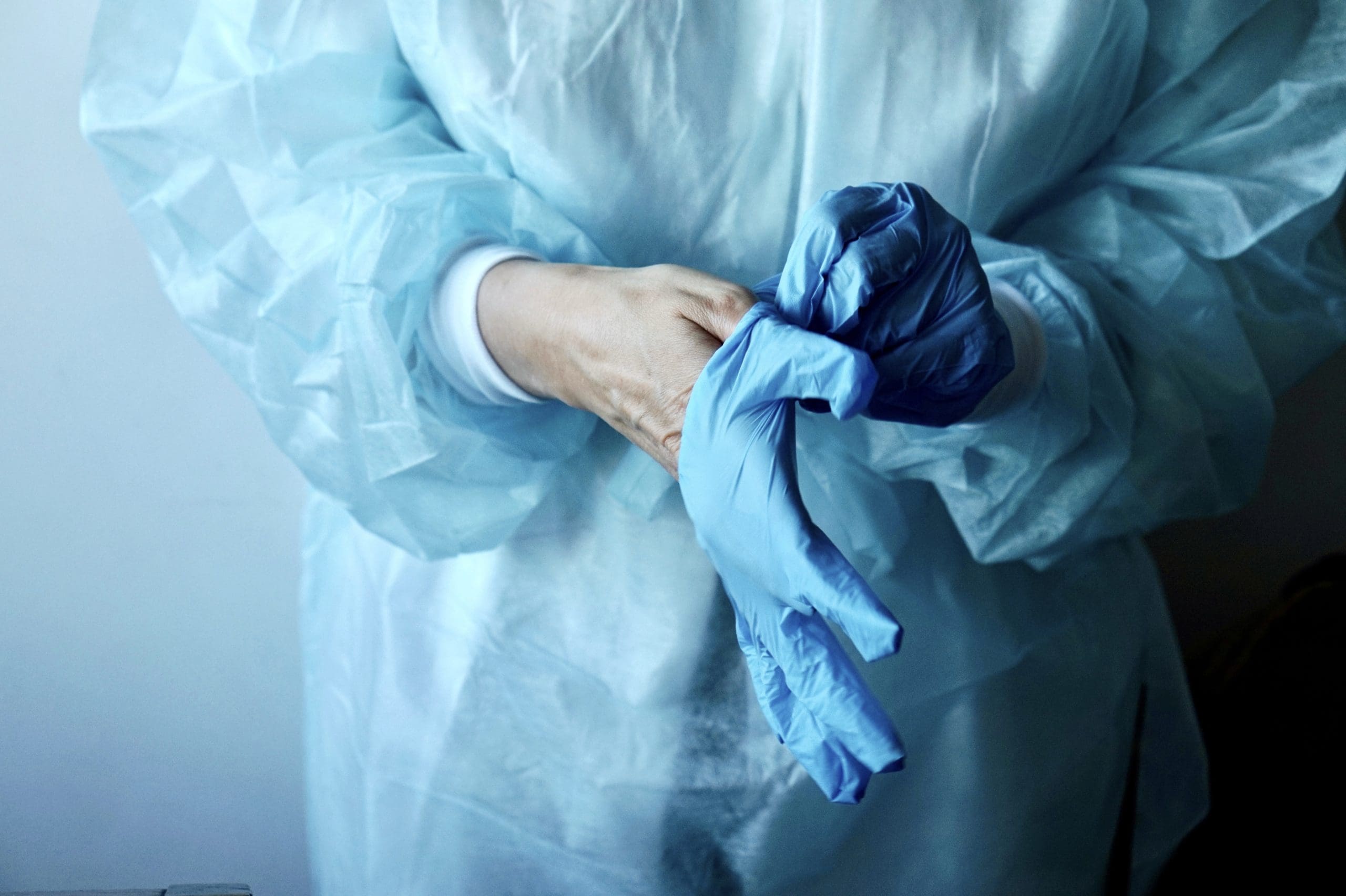 Doctor putting on latex gloves